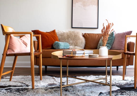 a living room with a brown couch and two chairs