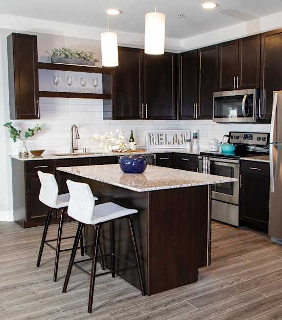 A kitchen with a white counter top and a stainless steel refrigerator at Avonlea in Lakeville, MN