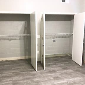 Two white closet doors open to reveal shelves.