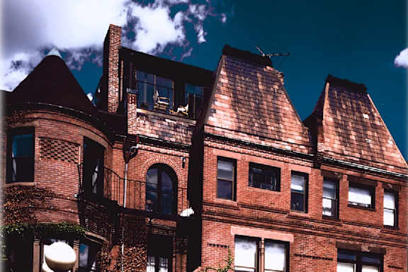 A large red brick building with ivy growing on it.