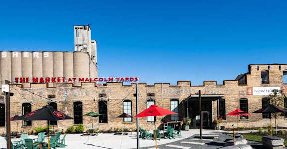 a courtyard with tables and umbrellas outside of the marquis palace