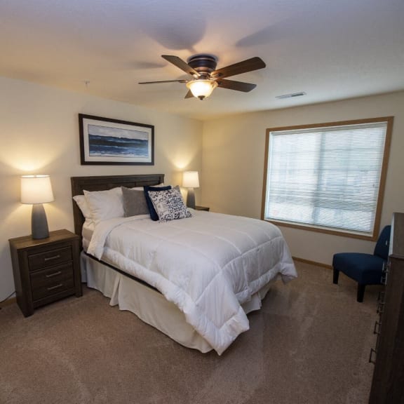 the master bedroom has a large bed and a ceiling fan