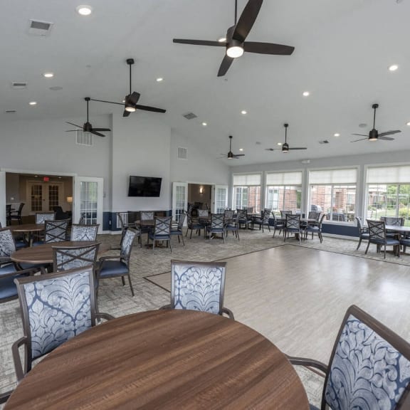a large room with tables and chairs and ceiling fans