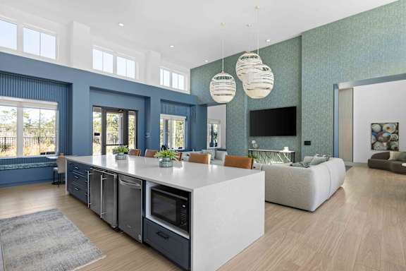 A modern kitchen with a large island and a dining area with a couch.  at The Quinn Luxury Apartments, Pensacola, FL