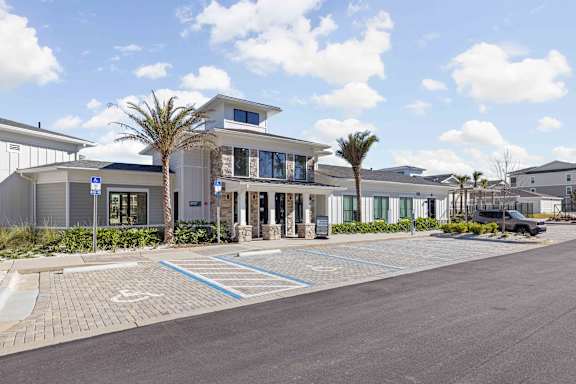 A modern building with a parking lot in front of it.  at The Quinn Luxury Apartments, Pensacola, FL