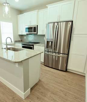 A kitchen with a granite countertop and stainless steel appliances.
