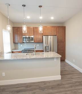 A kitchen with a granite countertop and wooden cabinets.