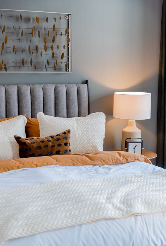 a bedroom with a bed and pillows and a lamp