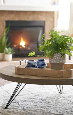 A fireplace with a tray of blue and white cups on it. at The Winhall of Williams Pointe Apartments, Waukee