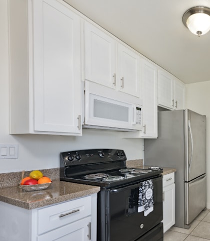 a kitchen with white cabinets and stainless steel appliances and a sink