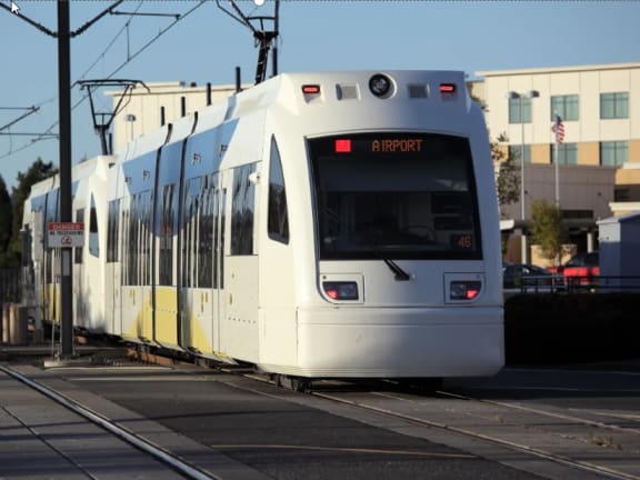 a TriMet max train on a track with a sky background