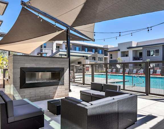 A patio with a fireplace and seating area.
