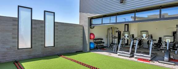 A gym with a green artificial turf in front of it.