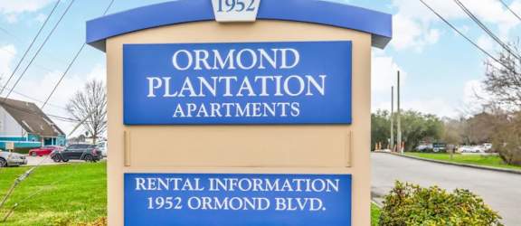 a sign in front of a building with a sky background