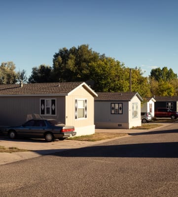 a row of houses with cars parked in front of them