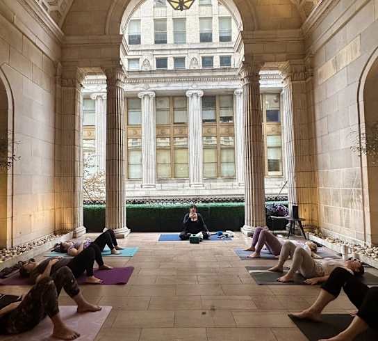 a group of people laying on yoga mats in a large building