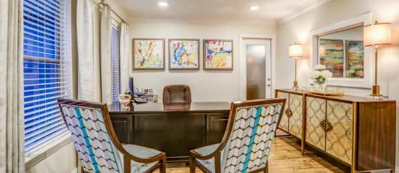 a desk and chairs in a room with a large window