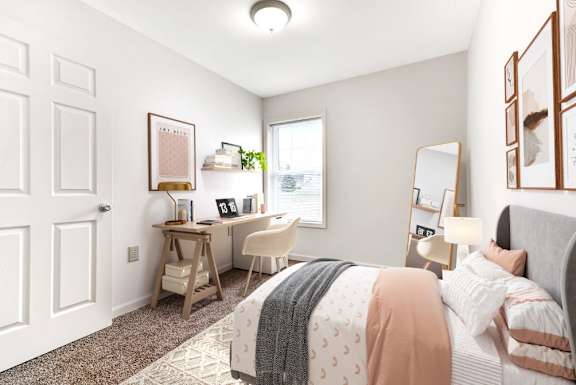 A bedroom with a bed, desk, and chair  at Summit Wood Apartments, Watertown, 13601