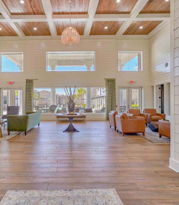 A modern living room with a stone fireplace and a large open space at Waterleaf at Neely Ferry Apartments, Simpsonville, SC