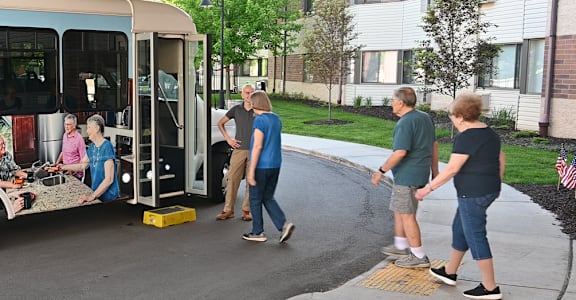 a group of people standing outside of a bus