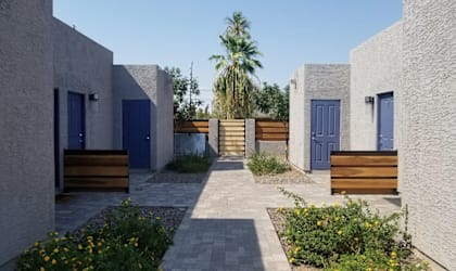 A row of houses with blue doors and wooden benches in front.