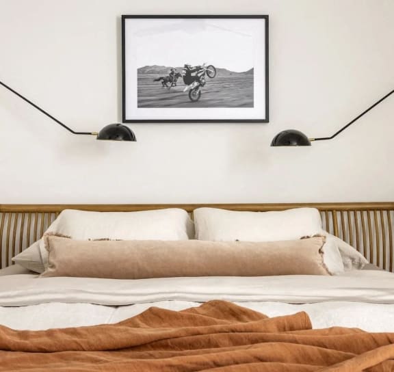a bedroom with a bed and a picture of a motorcycle on the wall