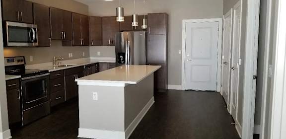 A kitchen with brown cabinets and a white island.