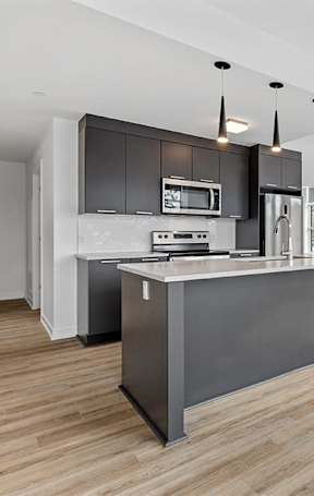 A modern kitchen with a large island and stainless steel appliances.