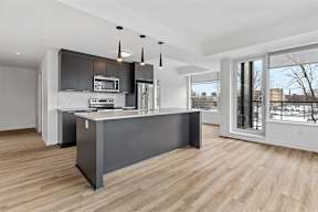 A modern kitchen with a large island and stainless steel appliances.