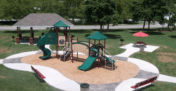 A playground with a green slide and a red slide.
