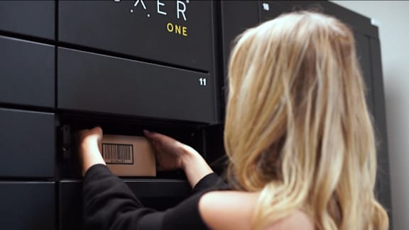 a woman pulling a package out of a locker