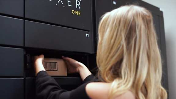 A woman is opening a black safe labeled