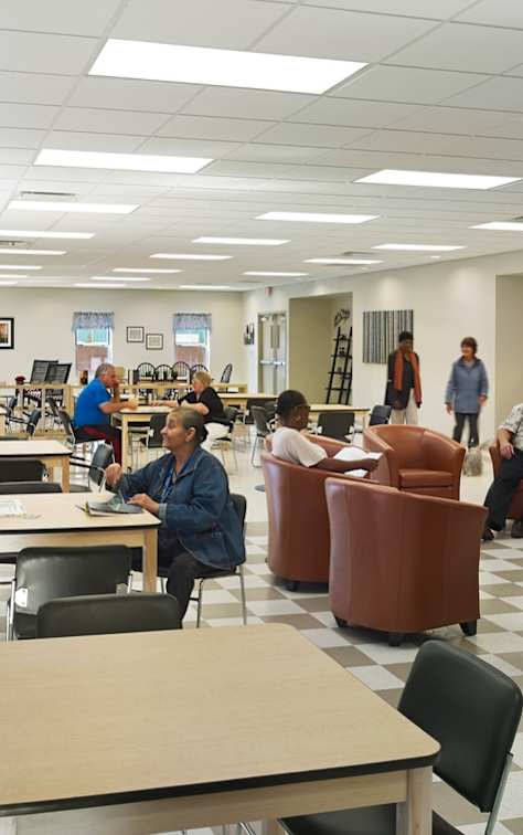 people sitting at tables and chairs in a library