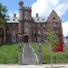 A large castle-like building with a black fence in front.at Art Of Newark, Newark, NJ