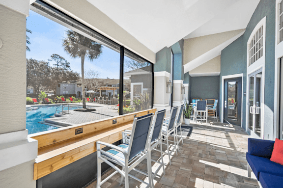 A patio with chairs and a pool in the background at Country Club Lakes, Jacksonville, 32224
