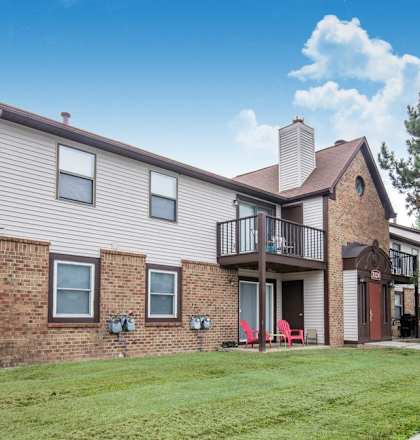 the exterior of a brick and with a balcony and grass