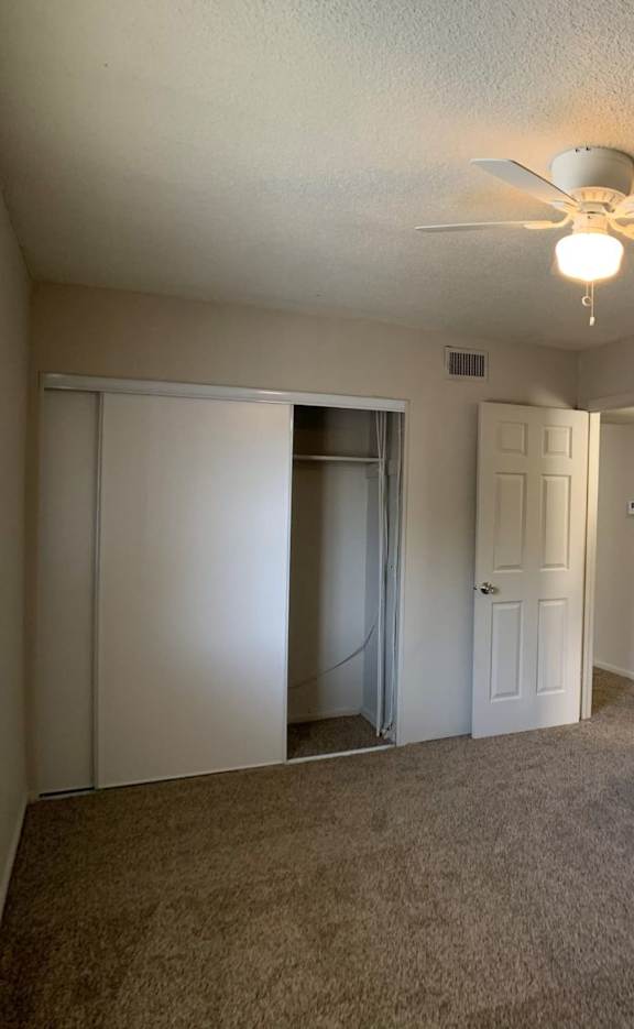 Bedroom with a bed, a ceiling fan, and a picture on the wall.