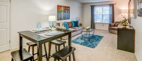 a living room with a table and chairs in front of a couch