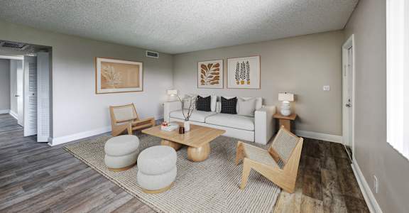 Open living area with wood-style flooring and large windows at Coronado Springs Apartments in Palm Springs, FL. Pet-friendly one- and two-bedroom apartments for rent.