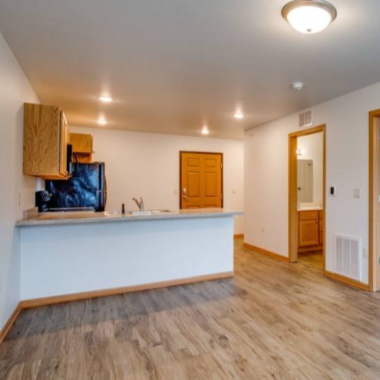 A room with a white wall and a wooden floor.