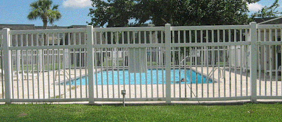 a white picket fence in front of a swimming pool