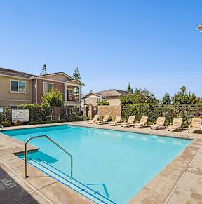 A swimming pool surrounded by lounge chairs and a sign that says "Welcome to the pool.".