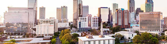 A cityscape with various buildings and a clear sky.