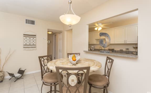 a dining area with a table and chairs and a kitchen