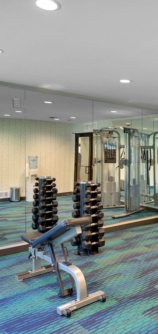 a gym with weights and cardio equipment in a room  at Pebblebrook Flats, Bloomington, 55437