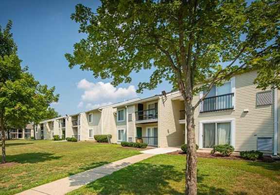 a picture of a building with a grassy area and trees
