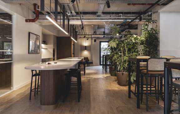 a kitchen with a long counter and bar stools