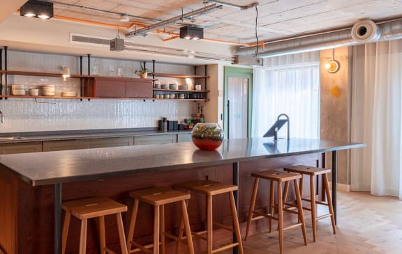 a kitchen with a long counter and bar stools