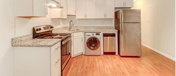 a kitchen with white cabinets and stainless steel appliances