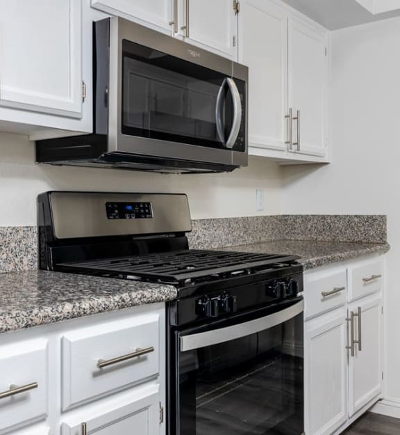 a kitchen with white cabinets and a black stove top oven